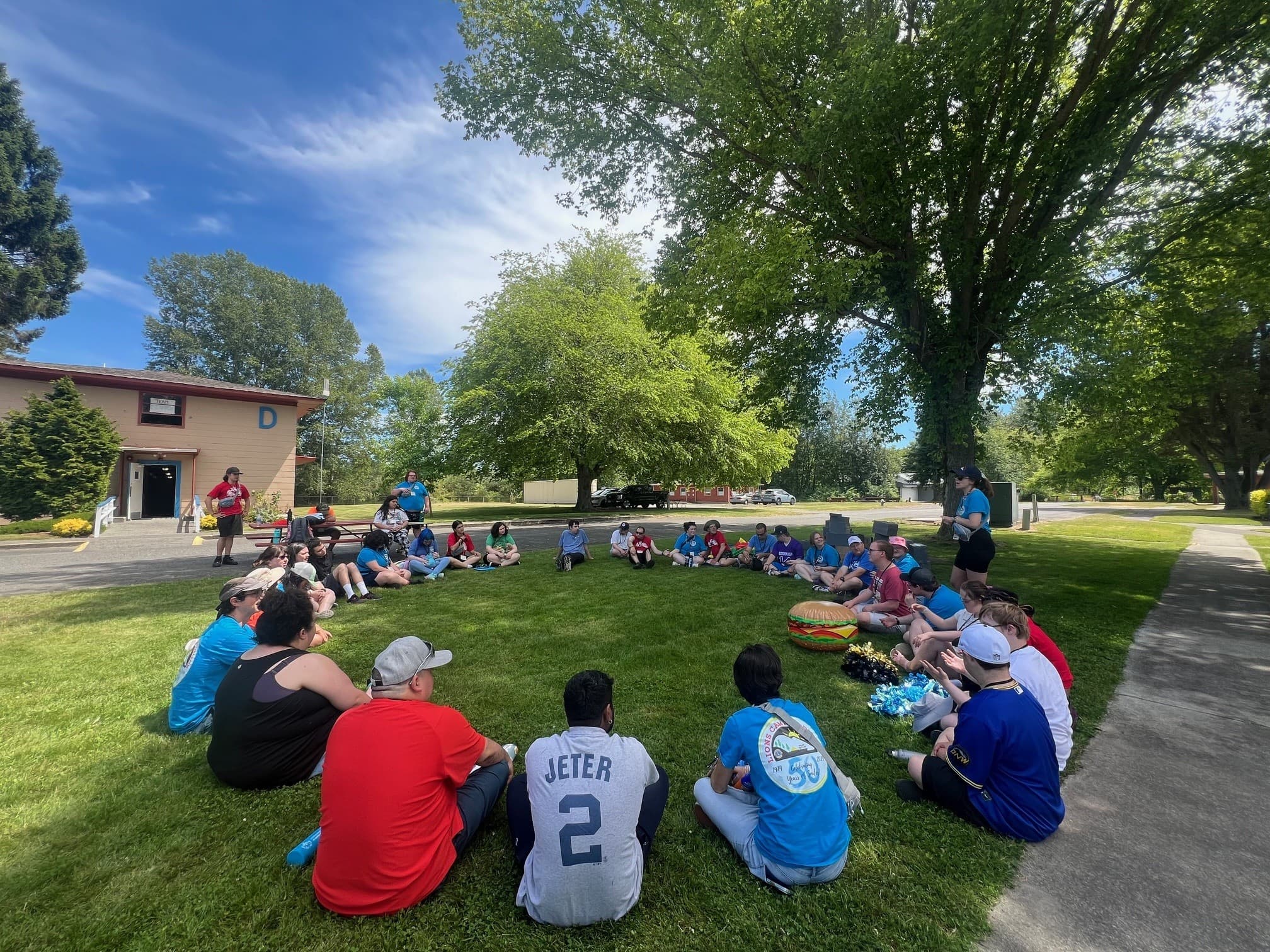 campers sitting in a circle on the grass